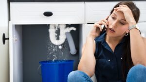 woman stressed over sink leaking