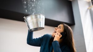 woman catching huge leak in the ceiling